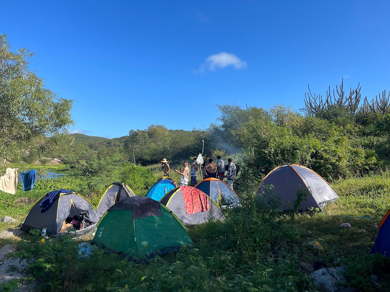 Camping à beira de rio com grupo de amigos em clima de descontração